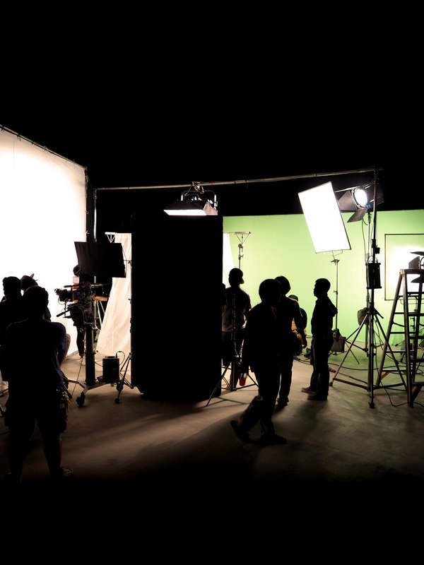 Crew silhouetted against lights on the Sunday Best set